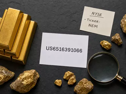 Newmont Corporation (US6516391066): Flatlay mit generischen Goldbarren, Erzstücken und Karte mit ISIN-Beschriftung - Foto: THN