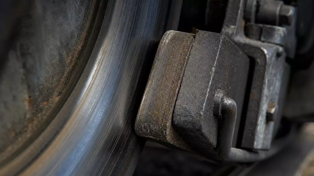 Makrofotografie eines Bremsklotzes und einer Stahlschiene mit Textur