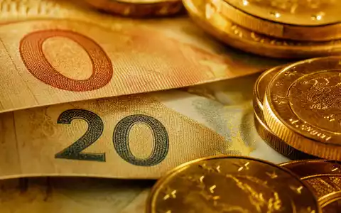 BNP Paribas S.A. FR0000131104 – Makroaufnahme von Euroscheinen und Goldmünzen in warmem Licht - Foto: THN