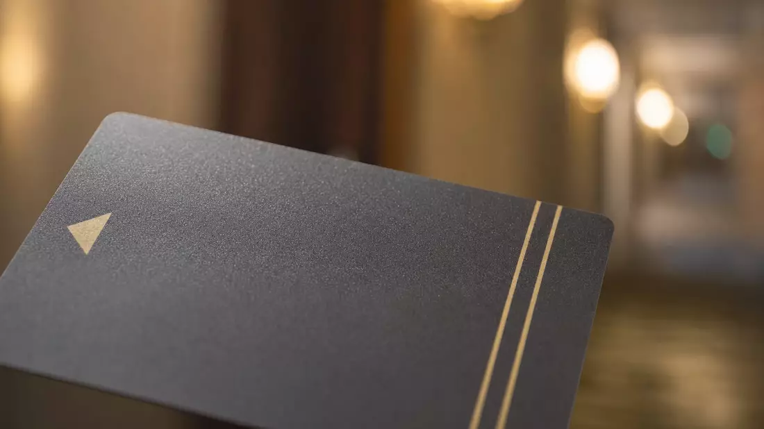 Extreme Nahaufnahme einer Hotelkarte mit goldenen Details und warmem Hintergrund-Bokeh