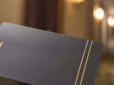 Booking Holdings Inc. Makroaufnahme einer eleganten Hotelzimmer-Schlüsselkarte mit warmem goldenem Bokeh US09857L1089 - Foto: THN