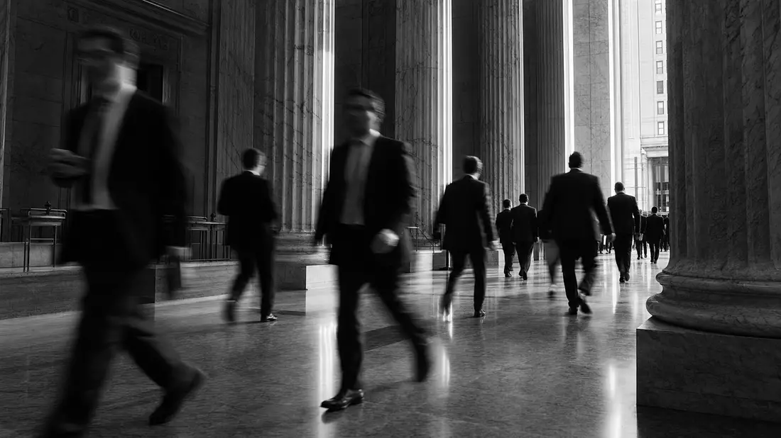 Schwarzweiß-Reportagefoto von Finanzmanagern in imposantem Marmor-Lobbykorridor