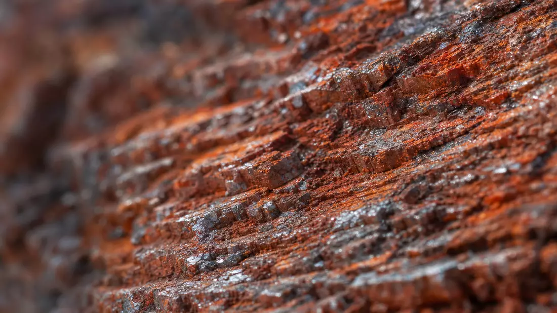 Extreme Makroaufnahme von rostrotem Eisenerzgestein mit metallischer Textur