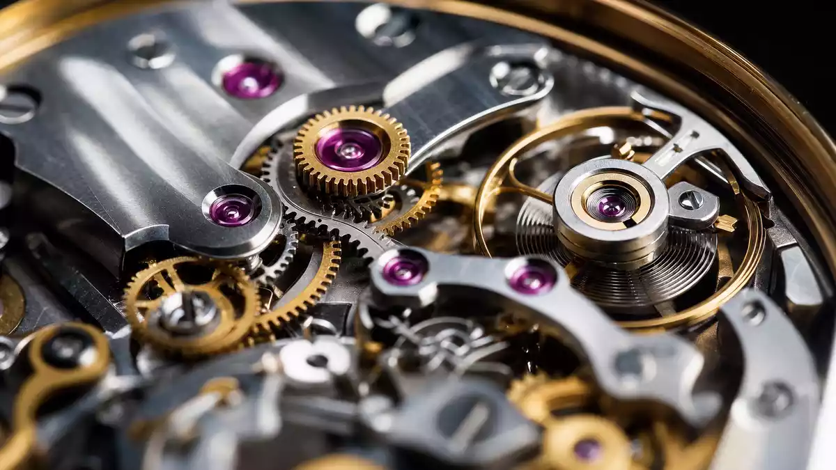 Extreme Nahaufnahme eines mechanischen Uhrwerks mit goldenen Zahnrädern und Rubinlagern
