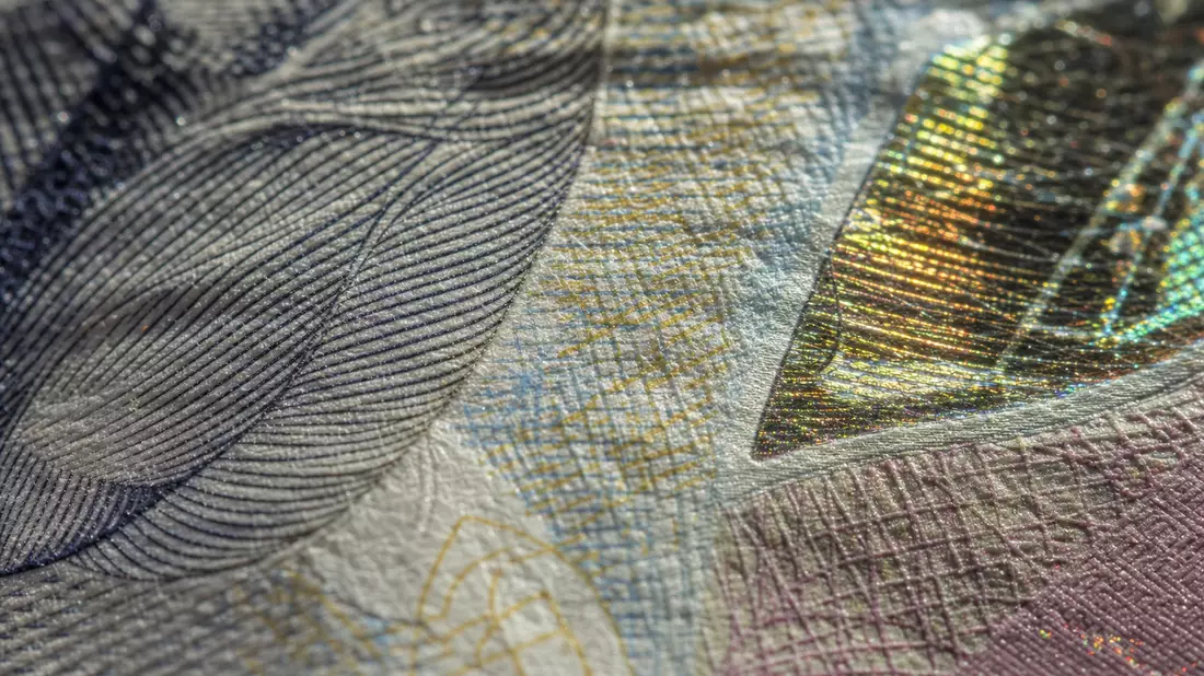 Makroaufnahme feiner Banknotenstrukturen mit Sicherheitsmerkmalen und Holografie