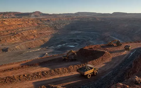 Glencore plc (ISIN JE00B4T3BW64) betreibt riesige Kupfertagebauten mit schweren Muldenkippern in staubiger Bergbaulandschaft - Foto: THN