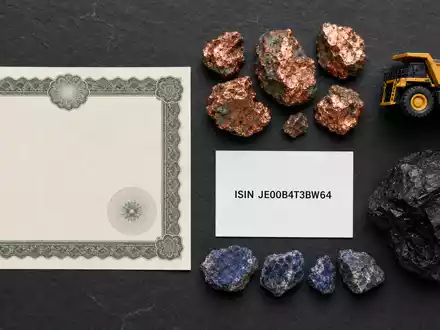 Flatlay mit Aktienzertifikat, ISIN-Karte und Rohstoffproben repräsentiert die Anlage in Glencore plc, JE00B4T3BW64 - Foto: THN
