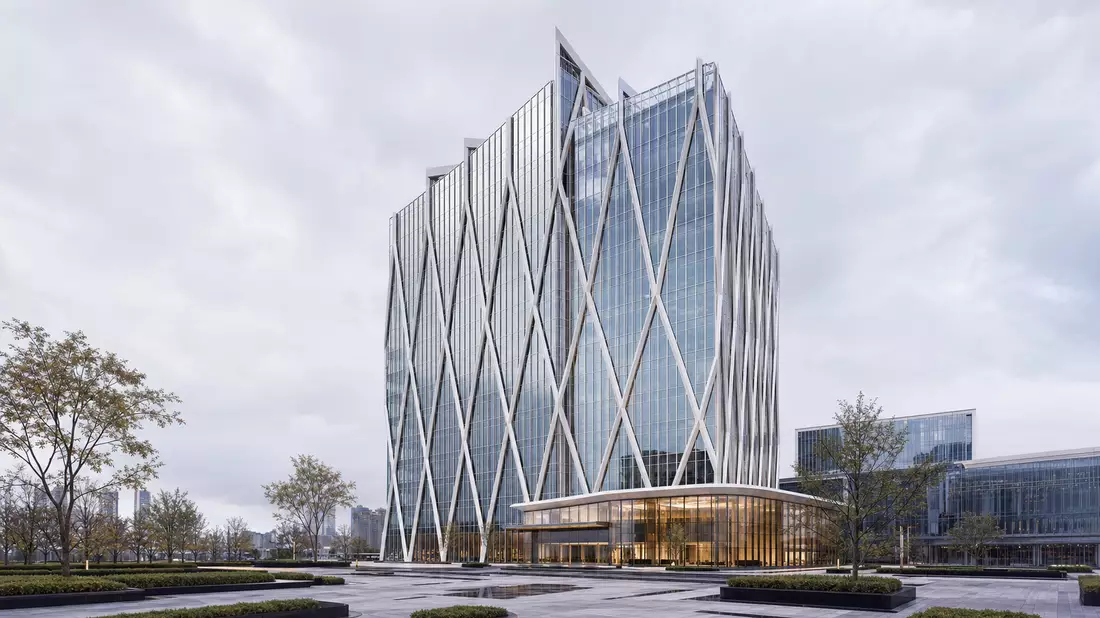 CGI-Render eines modernen Konzernhochhauses mit Glasfassade, Gitterstruktur und Eingangsplatz
