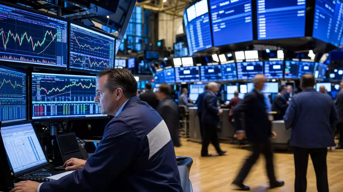 Börsen-Editorial mit Händler vor Monitoren mit Telekommunikationsaktien-Charts auf dem NYSE-Parkett