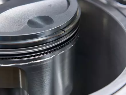BMW AG (DE0005190003): extreme Makroaufnahme eines polierten Aluminium-Kolbens mit feinen Bearbeitungsspuren im Motorzylinder - Foto: THN
