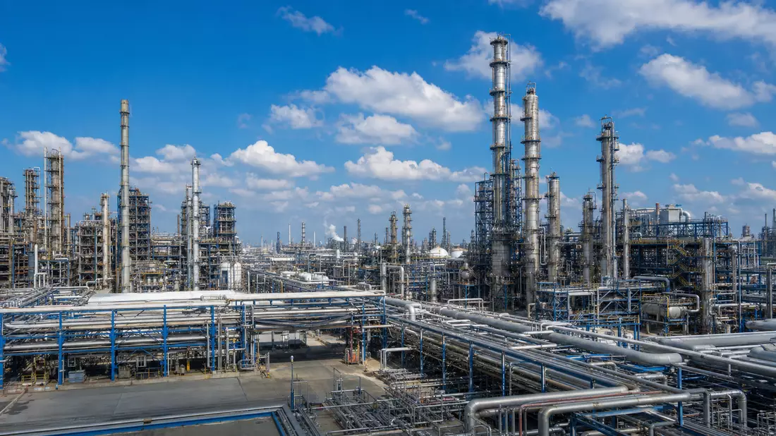 Fotorealistische Chemieanlage mit Rohrleitungen und Cracker-Türmen unter blauem Himmel