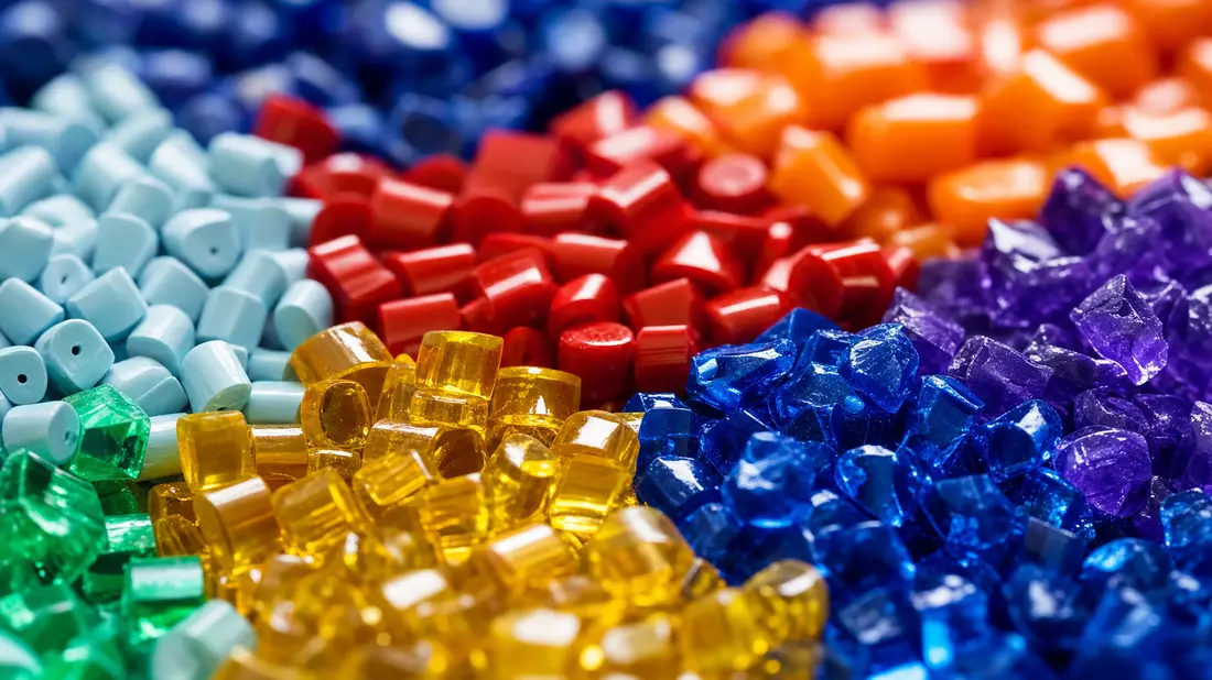 Makroaufnahme von bunten glänzenden Kunststoff-Pellets in verschiedenen Farben