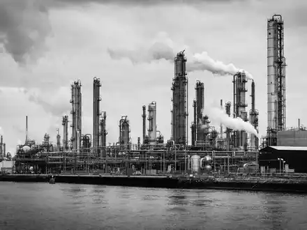 Bayer AG (DE000BAY0017): dokumentarische Schwarzweiß-Reportage-Aufnahme einer großen Chemiefabrik am Rheinufer mit hohen Türmen - Foto: THN