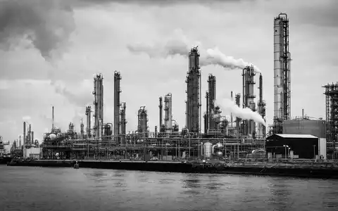Bayer AG (DE000BAY0017): dokumentarische Schwarzweiß-Reportage-Aufnahme einer großen Chemiefabrik am Rheinufer mit hohen Türmen - Foto: THN