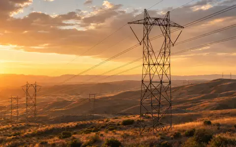 Edison International US2810201077 Hochspannungsmasten bei Sonnenaufgang über südkalifornischen Hügeln in goldenes Licht getaucht - Foto: THN