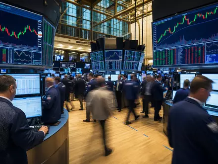 Edison International US2810201077 lebhafter NYSE-Börsenparkett mit aktiven Händlern und großen Candlestick-Kursdiagrammen des Energiesektors - Foto: THN