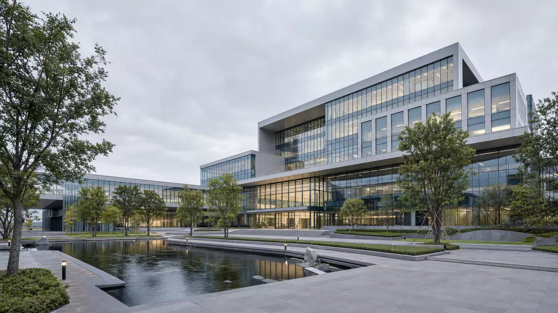 Architektur-Render eines modernen Glas-Stahl-Campusgebäudes mit begrünter Plaza