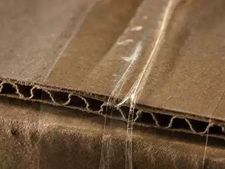 eBay Inc. Verpackungsmaterial ISIN US2786421030 als extreme Makroaufnahme von Wellpappe mit Klebeband-Textur - Foto: THN