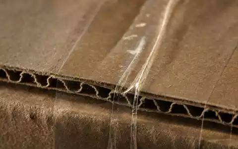 eBay Inc. Verpackungsmaterial ISIN US2786421030 als extreme Makroaufnahme von Wellpappe mit Klebeband-Textur - Foto: THN