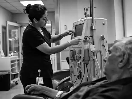 Schwarzweiß-Reportage zeigt Pflegekraft an Dialysegerät, symbolisch für Fresenius Medical Care AG DE0005785802 in klinischer Umgebung - Foto: THN