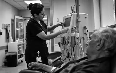 Schwarzweiß-Reportage zeigt Pflegekraft an Dialysegerät, symbolisch für Fresenius Medical Care AG DE0005785802 in klinischer Umgebung - Foto: THN