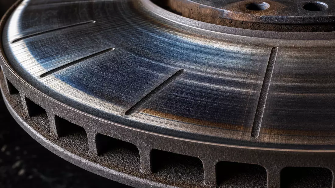 Makroaufnahme einer Bremsscheibe mit Hitzeverfärbung und Metalltextur