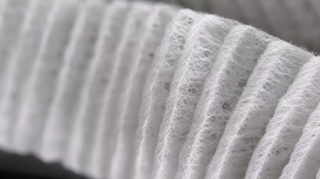Makroaufnahme einer feinen weißen Membranfilter-Faserstruktur mit dramatischem Licht