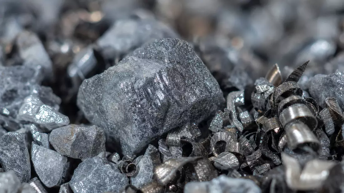 Extreme Makroaufnahme von grauem Erzgestein mit glänzenden Metallspänen