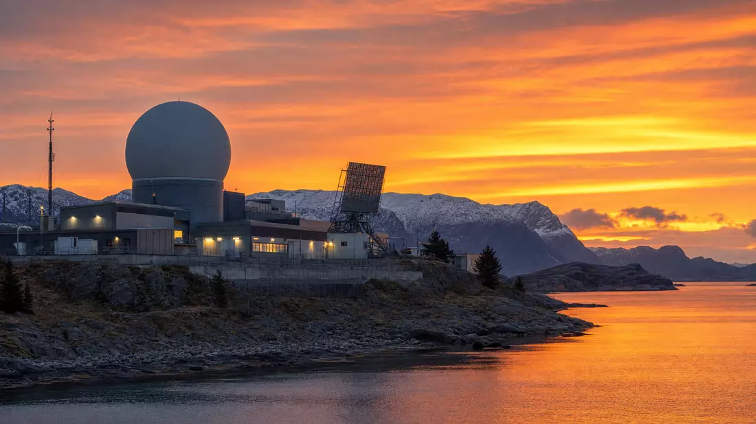 Fotorealistische Verteidigungsanlage mit Radarturm bei Dämmerung, norwegische Küstenlandschaft
