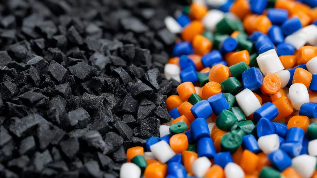 Makrofoto von schwarzem Kautschukgranulat und bunten Kunststoffpellets nebeneinander