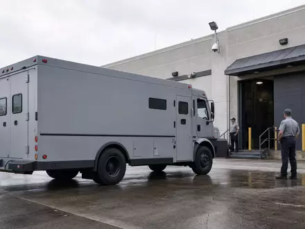Fotorealistisches Bild zeigt Loomis AB SE0014556112 mit gepanzertem Geldtransporter vor Sicherheitszentrum in Stockholm - Foto: THN