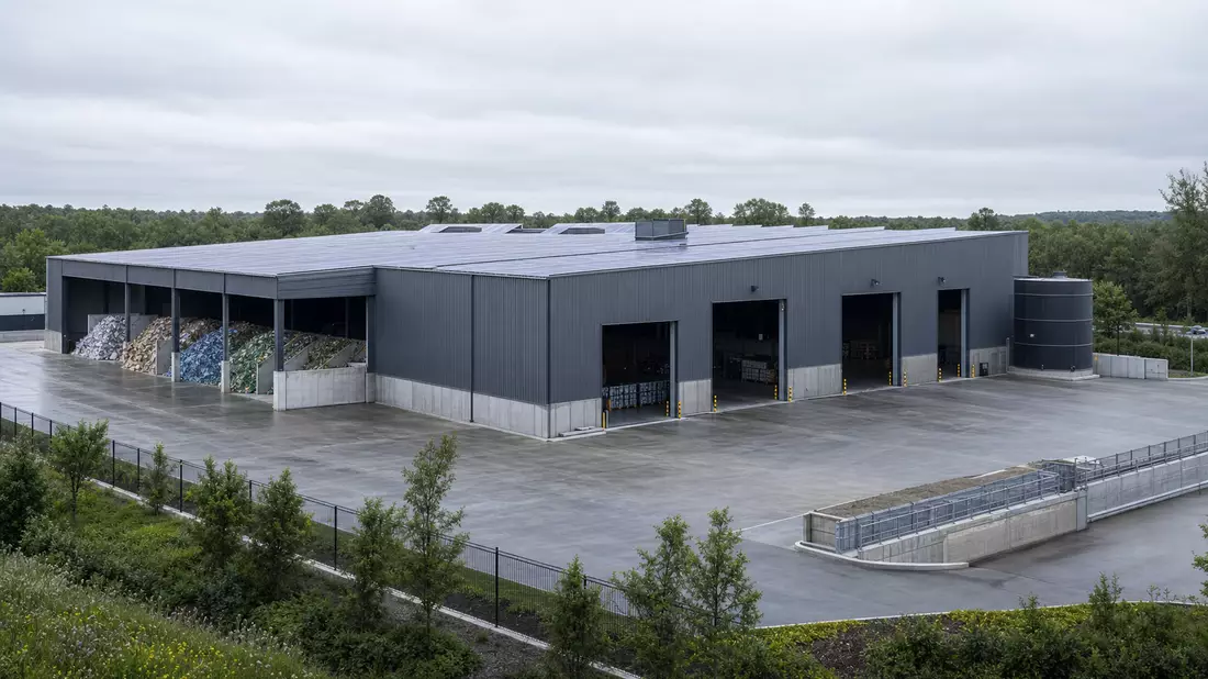 3D-Architekturvisualisierung einer modernen Recyclinganlage mit Ladebuchten und Solardach