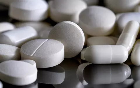 Redcare Pharmacy (Shop Apoth), ISIN NL0012044747, zeigt Makroaufnahme markenfreier weißer Tabletten und Kapseln mit Streiflicht - Foto: THN