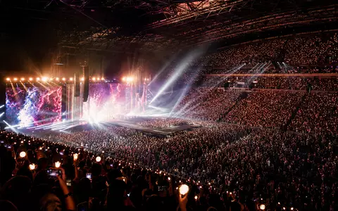 CTS Eventim DE0005470306 zeigt eine vollbesetzte Indoor-Arena mit farbenfrohem Bühnenspektakel und jubelndem Publikum - Foto: THN