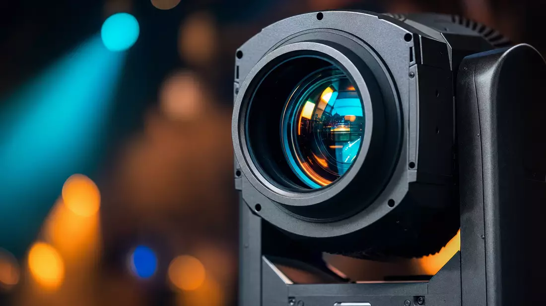 Makroaufnahme einer professionellen Bühnenscheinwerferlinse mit bunter Lichtbrechung im Bokeh