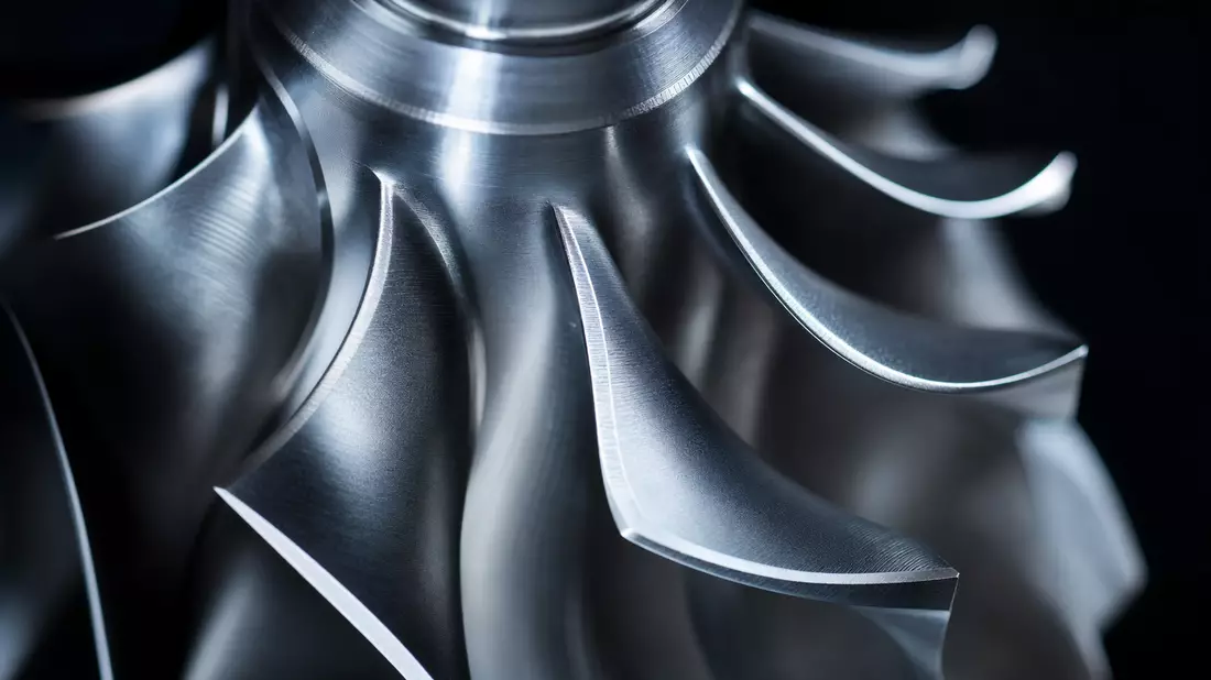 Extreme Makroaufnahme eines Turbinenrads mit polierten Aluminium-Schaufeln und Tiefenschärfe