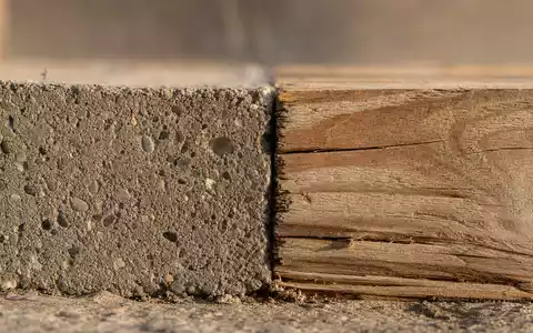 D.R. Horton Inc. US23331A1097 Makromotiv zeigt Beton- und Holzmaserung als Baumaterialstudie im warmen Licht - Foto: THN