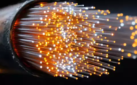 Digital Realty Trust Makroaufnahme leuchtender Glasfaser Kabel Enden als abstrakte Lichtpunkte vor Dunkel US2538681030 - Foto: THN