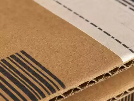 DHL Group (Deutsche Post) Makro-Detailaufnahme Wellpapp-Karton mit Barcode, DAX Aktie ISIN DE0005552004 - Foto: THN