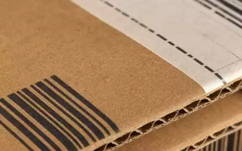 DHL Group (Deutsche Post) Makro-Detailaufnahme Wellpapp-Karton mit Barcode, DAX Aktie ISIN DE0005552004 - Foto: THN