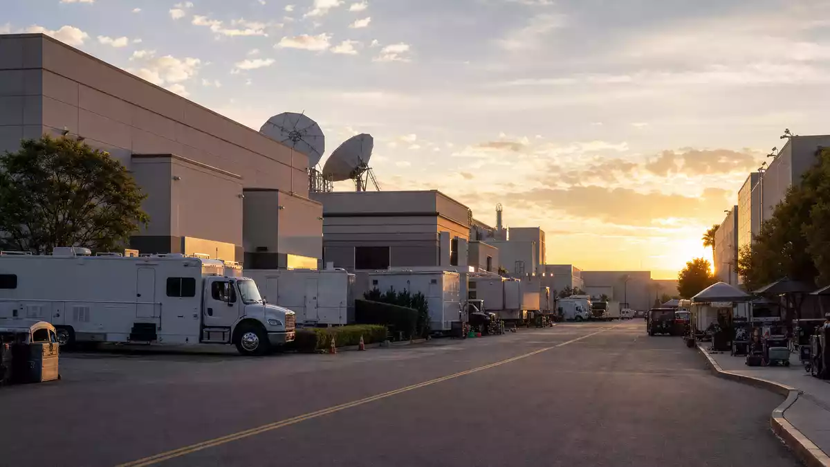 Generischer Filmstudio-Komplex mit Produktionstrucks bei Sonnenuntergang