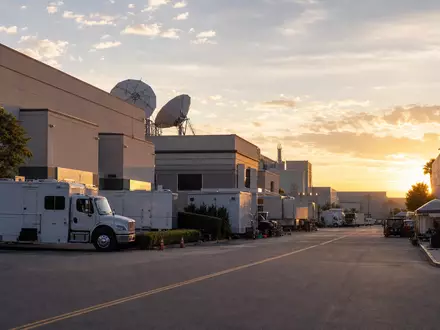 Disney (Walt) Co. US2546871060 Filmstudio-Campus mit Produktionsfahrzeugen und Satellitenschüsseln im goldenen Abendlicht - Foto: THN