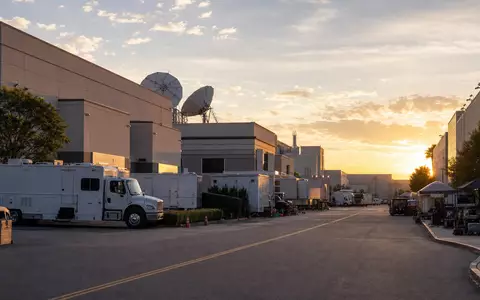Disney (Walt) Co. US2546871060 Filmstudio-Campus mit Produktionsfahrzeugen und SatellitenschĂĽsseln im goldenen Abendlicht - Foto: THN