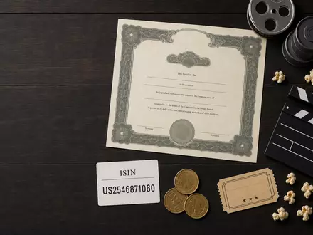Disney (Walt) Co. US2546871060 Flatlay mit Aktienzertifikat ISIN-Karte Filmrollen und branchentypischen Utensilien auf Holz - Foto: THN