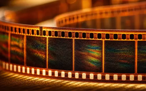 Disney (Walt) Co. US2546871060 extreme Makroaufnahme eines 35-mm-Filmstreifens mit Lichtbrechung und warmen Bernsteintönen - Foto: THN