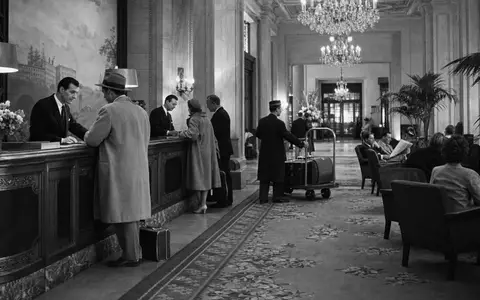 Expedia Group Inc. US30212P3038 – Dokumentarische Schwarz-Weiß-Reportage eines eleganten Hotelempfangs mit Gästen - Foto: THN