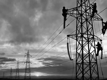 Exelon Corp. Schwarzweiß Reportage zeigt Monteure an Hochspannungsmasten, ISIN US30161N1019, dramatische Industriekulisse - Foto: THN