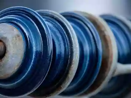 Exelon Corp. Makro Detailaufnahme blauer Keramik Isolatoren am Strommast, ISIN US30161N1019, industrielle Oberflächentextur - Foto: THN