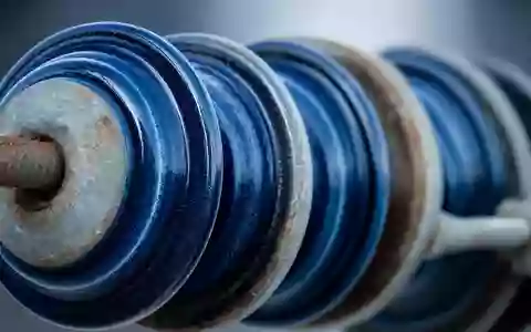 Exelon Corp. Makro Detailaufnahme blauer Keramik Isolatoren am Strommast, ISIN US30161N1019, industrielle Oberflächentextur - Foto: THN
