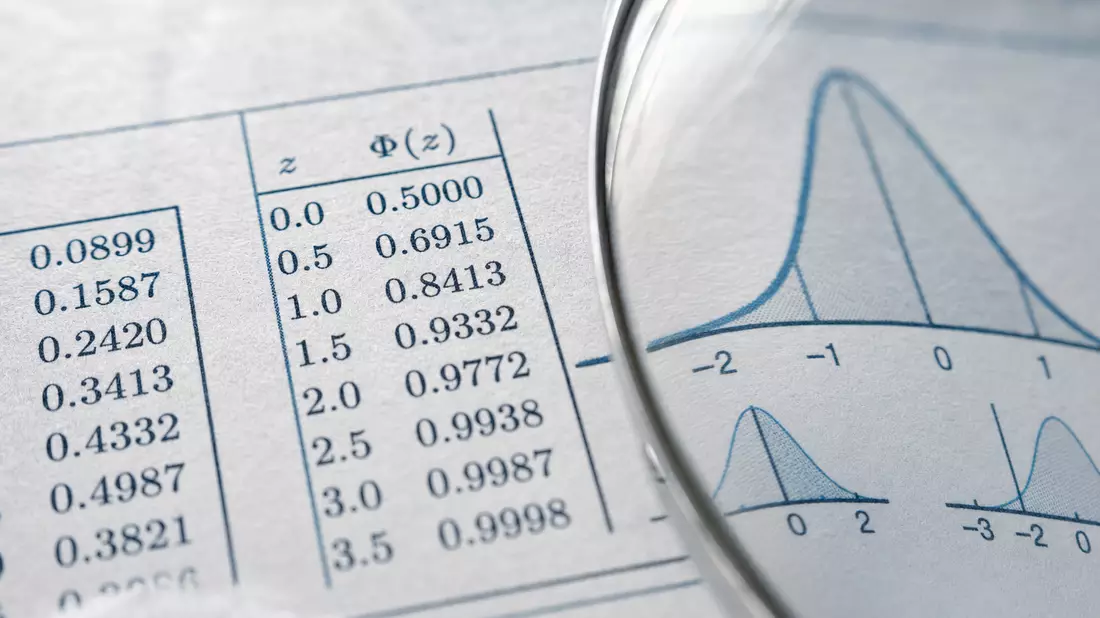 Makroaufnahme von statistischen Tabellen und Kurven unter einer Lupe